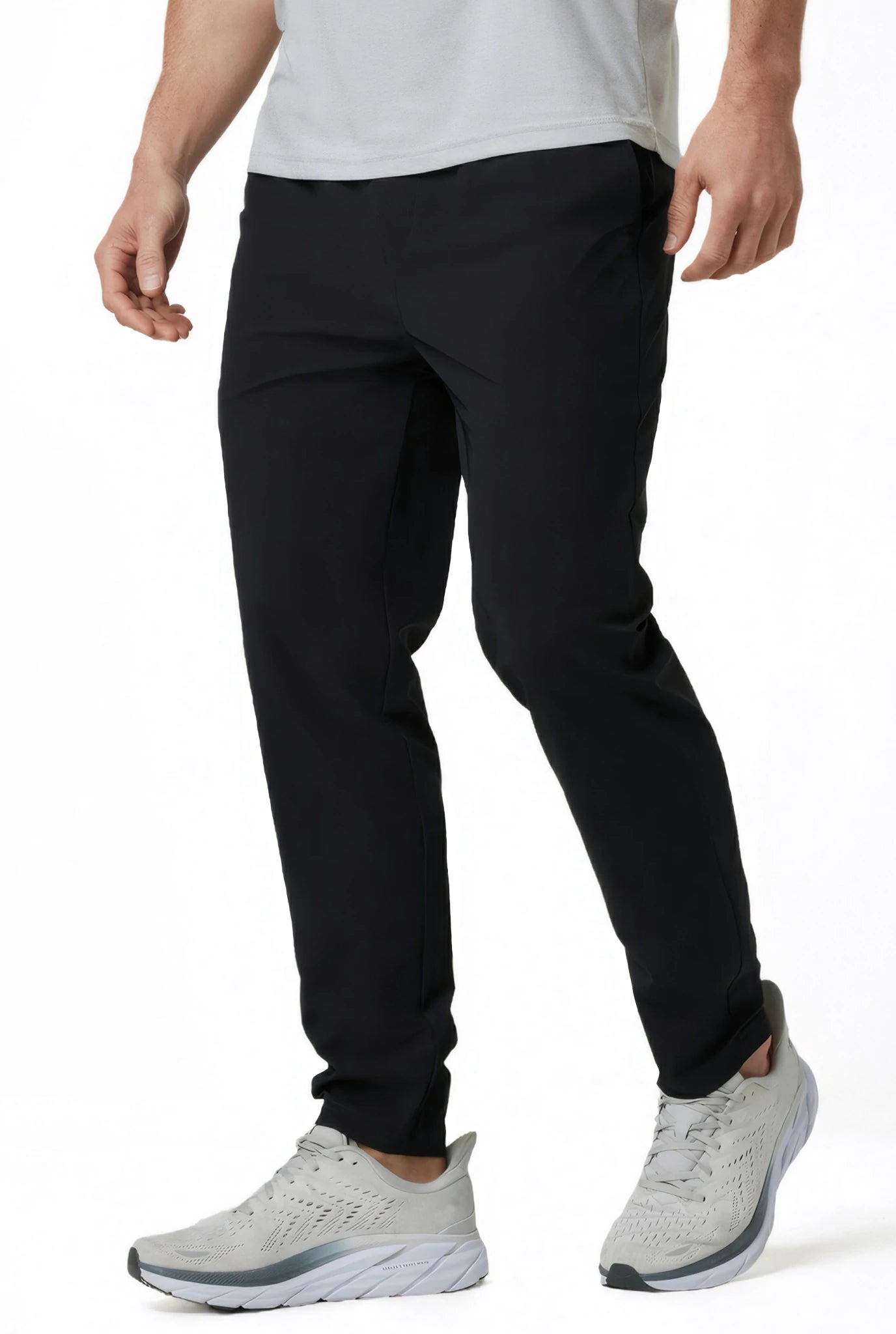 side view of a man wearing solid black athletic pants with two side pockets