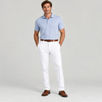 Man wearing Dexonmen men's classic fit white dress pants styled with light blue polo and brown belt for office or formal wear