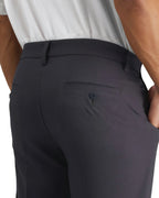 a close-up of the button back pocket of mens grey pants