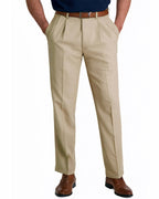 front view of a man wearing solid khaki pleated dress pants with button and zipper closure